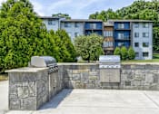 Thumbnail 31 of 39 - Grilling stations at Woods of Fairfax, offering residents outdoor cooking spaces with grills.