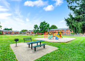Thumbnail 9 of 17 - Apartment playground and picnic area at Mount Vernon, featuring play equipment, benches, and open space for outdoor activities.