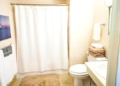 Thumbnail 8 of 9 - Bathroom in a one-bedroom apartment at Village Square Apartments with a toilet, sink, and a tub.