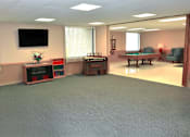 Thumbnail 6 of 17 - Entertainment area with a pool table, a television, and a small piano at Kentwood Square Apartments.