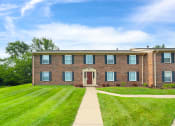 Thumbnail 11 of 13 - Exterior view of Carriage House Apartments in New Albany, showcasing the building's architecture and surrounding landscape.