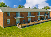 Thumbnail 9 of 15 - Building exterior at Cambridge Square Apartments in Flint, featuring balconies and patios with well-maintained landscaping.