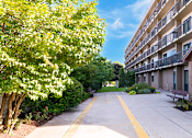 Thumbnail 6 of 9 - Exterior view of Village Square Apartments featuring balconies.