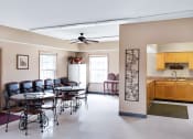 Thumbnail 5 of 13 - Clubhouse at Carriage House Apartments in New Albany, featuring a dining room with a table and chairs, a fully-equipped kitchen, and a welcoming space for residents to socialize.
