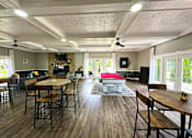 Thumbnail 11 of 63 - Interior of the clubhouse at Woodbridge Apartments in Bloomington, featuring furniture, pool table, and seating areas.