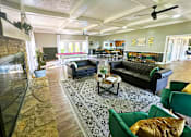 Thumbnail 12 of 63 - Interior of the clubhouse at Woodbridge Apartments in Bloomington, featuring furniture, pool table, and seating areas.