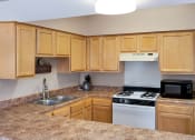 Thumbnail 3 of 13 - Clubhouse kitchen at Carriage House Apartments in New Albany, featuring appliances, spacious countertops and cabinets.