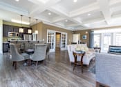 Thumbnail 5 of 27 - A spacious living room with a kitchen area in the background.