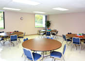 Thumbnail 5 of 17 - Community room with tables and chairs at Kentwood Square Apartments.
