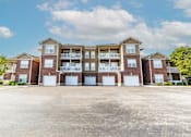 Thumbnail 11 of 27 - A large apartment complex with multiple balconies and garage doors.