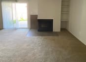 Thumbnail 13 of 21 - Townhome living room at Ashley Pointe Apartments with a fireplace and a sliding door to patio