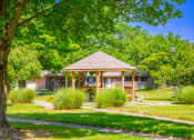 Thumbnail 7 of 16 - Gazebo at Cambridge Square Apartments in Greenwood, surrounded by greenery, for relaxation.