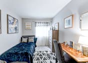 Thumbnail 14 of 39 - Guest bedroom in a 2-bedroom, 1-bath apartment at Woods of Fairfax, featuring cozy furnishings and natural light.