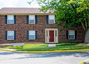 Thumbnail 2 of 9 - A red door is on the front of a brick building.