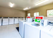 Thumbnail 9 of 9 - A laundromat with rows of washers and dryers.
