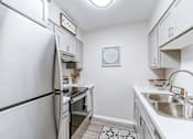 Thumbnail 3 of 39 - Kitchen in a 2-bedroom, 1-bath apartment at Woods of Fairfax, with an electric stove and stainless steel appliances.