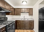 Thumbnail 1 of 15 - Kitchen in a 2-bedroom, 1-bath apartment at Cambridge Square Apartments in Flint, featuring kitchen appliances, ample cabinetry, and a functional layout.