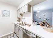 Thumbnail 2 of 39 - Kitchen and dining room in a 2-bedroom, 1-bath apartment at Woods of Fairfax, featuring a sink and dining space.