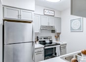 Thumbnail 1 of 39 - Kitchen in a 2-bedroom, 1-bath apartment at Woods of Fairfax, with an electric stove and stainless steel appliances.