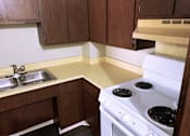Thumbnail 1 of 13 - Kitchen with a stove, sink and  wooden cabinets at Marshall House Apartments.