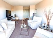 Thumbnail 1 of 9 - Living room with furniture and a flat screen TV at Village Square Apartments.