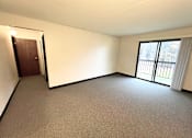 Thumbnail 3 of 17 - Living room with patio access in a one-bedroom, one-bathroom apartment at Kentwood Square Apartments.