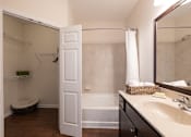 Thumbnail 22 of 27 - A white bathroom with a white door open to a white shower.
