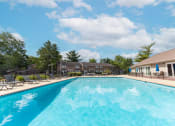 Thumbnail 9 of 23 - Outdoor swimming pool with seating at Woodbridge Apartments