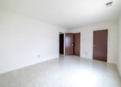 Thumbnail 14 of 15 - Three brown doors in a white room.