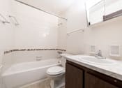 Thumbnail 15 of 15 - A white bathroom with a toilet, sink, and bathtub.