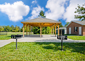 Thumbnail 12 of 15 - Picnic area at Cambridge Square Apartments in Flint, featuring a gazebo and BBQ grills.