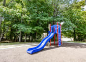 Thumbnail 10 of 23 - Playground with a slide and climbing apparatus at Woodbridge Apartments