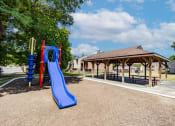 Thumbnail 11 of 23 - Playground with shaded pavilion at  Woodbridge Apartments