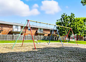 Thumbnail 10 of 16 - Playground with a swing set  at Ashton Pointe Apartments.