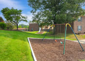 Thumbnail 6 of 13 - Playground at Carriage House Apartments in New Albany, featuring a swing set.