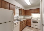 Thumbnail 2 of 21 - Townhome kitchen at Ashley Pointe Apartments with white appliances and lots of cabinets