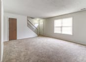 Thumbnail 11 of 21 - Townhome living room with access to the front door and stairs at Ashley Pointe Apartments