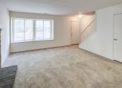 Thumbnail 22 of 25 - Townhome living room with windows and stairs to the next level at The Woods of Eagle Creek