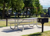 Thumbnail 4 of 12 - Playground with grilling stations at Woodlake Apartments