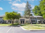 Thumbnail 7 of 12 - Exterior building with front row parking at Woodlake Apartments