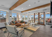 Thumbnail 5 of 37 - Spacious living room with wood beams and patio access at The Lyric Apartments, Seattle, WA