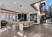 Thumbnail 16 of 37 - Spacious dining area with spiral staircase feature at The Lyric Apartments, Seattle, WA
