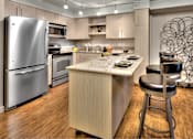 Thumbnail 35 of 37 - Contemporary kitchen with island seating and stainless appliances at The Lyric Apartments, Seattle, Washington