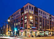 Thumbnail 1 of 37 - Contemporary brick building exterior at twilight at The Lyric Apartments, Seattle, WA 98102