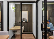 Thumbnail 25 of 37 - Private work booth with desk and acoustic paneling at The Lyric Apartments, Seattle, WA