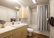 Thumbnail 36 of 37 - Bathroom with wood vanity and tub shower combo at The Lyric Apartments, Seattle, 98102