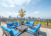 Thumbnail 3 of 37 - Rooftop terrace with blue seating and fire pit at The Lyric Apartments, Seattle
