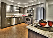 Thumbnail 4 of 37 - Modern kitchen with stainless steel appliances and granite counters at The Lyric Apartments, Seattle, WA 98102