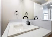 Thumbnail 30 of 37 - Corner bathroom sink with black faucet and towel ring at The Lyric Apartments, Washington, 98102