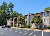 Thumbnail 16 of 29 - Apartment building with a parking lot in front.